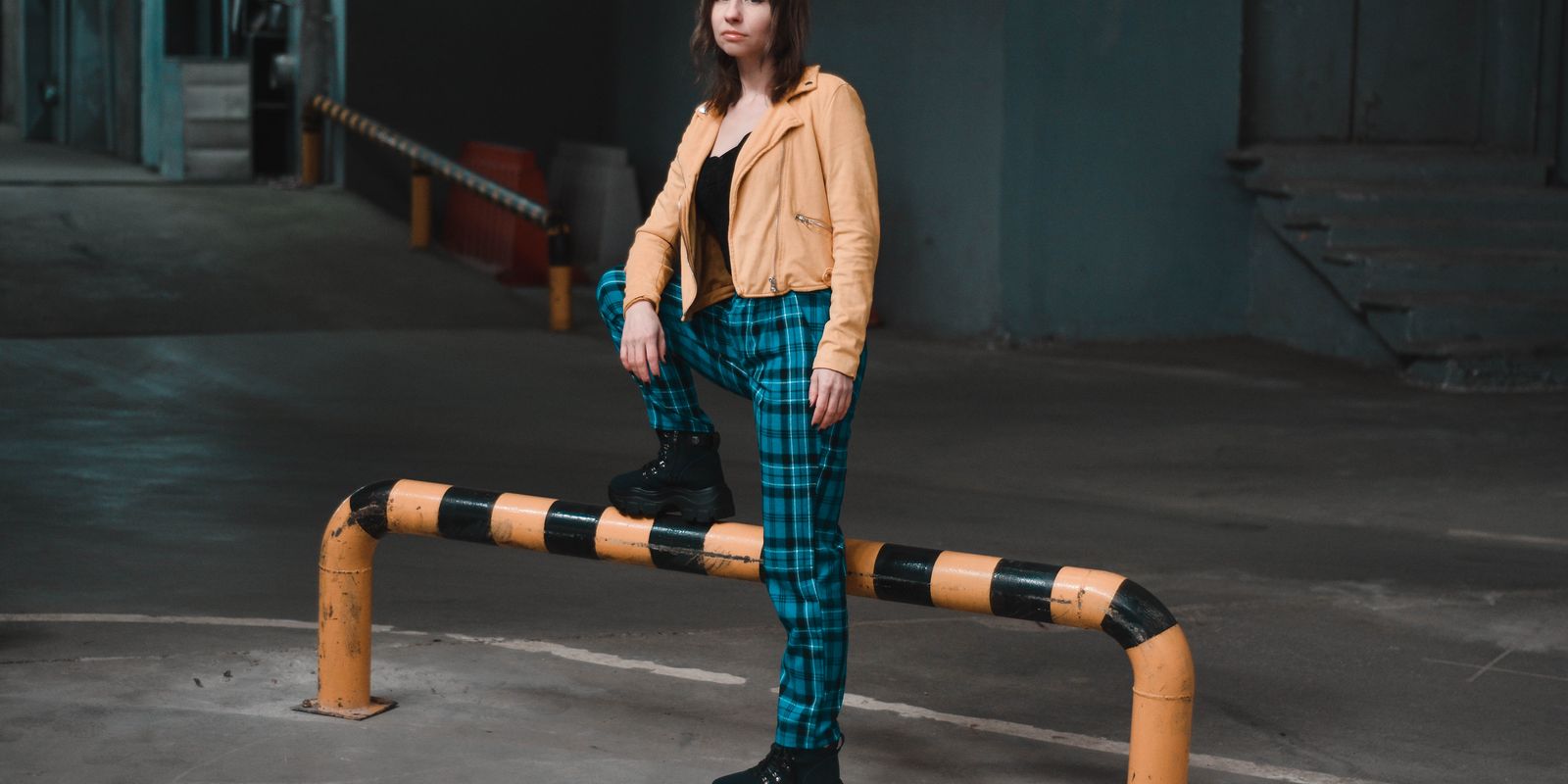Full length shot of a stylish person standing confidently in a jacket on an urban underground level