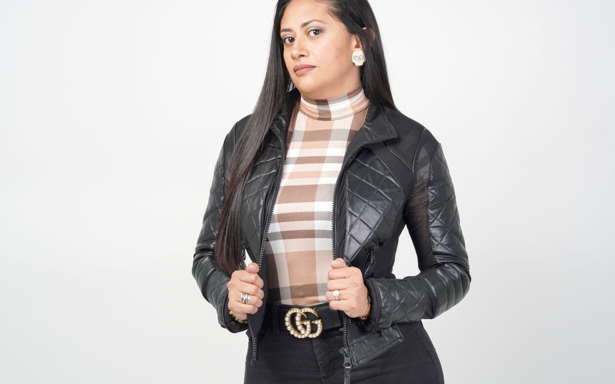 A woman wearing a black leather jacket, styled with confidence for cooler weather
