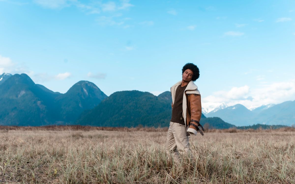 Man in a warm shearling-style aviator jacket standing in an open field