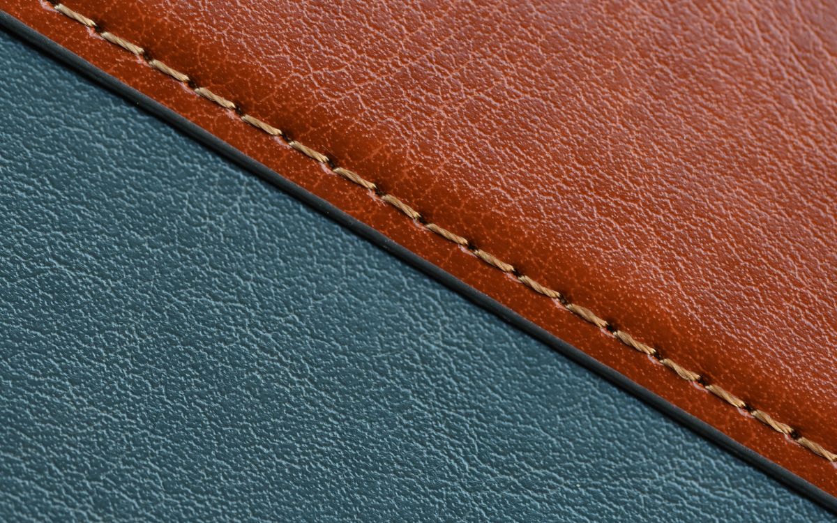 A detailed close-up of stitched leather showing natural grain and craftsmanship