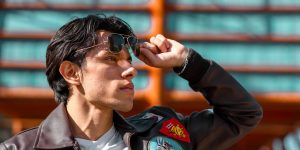 Fashionable man in sunglasses and a leather jacket posing outdoors