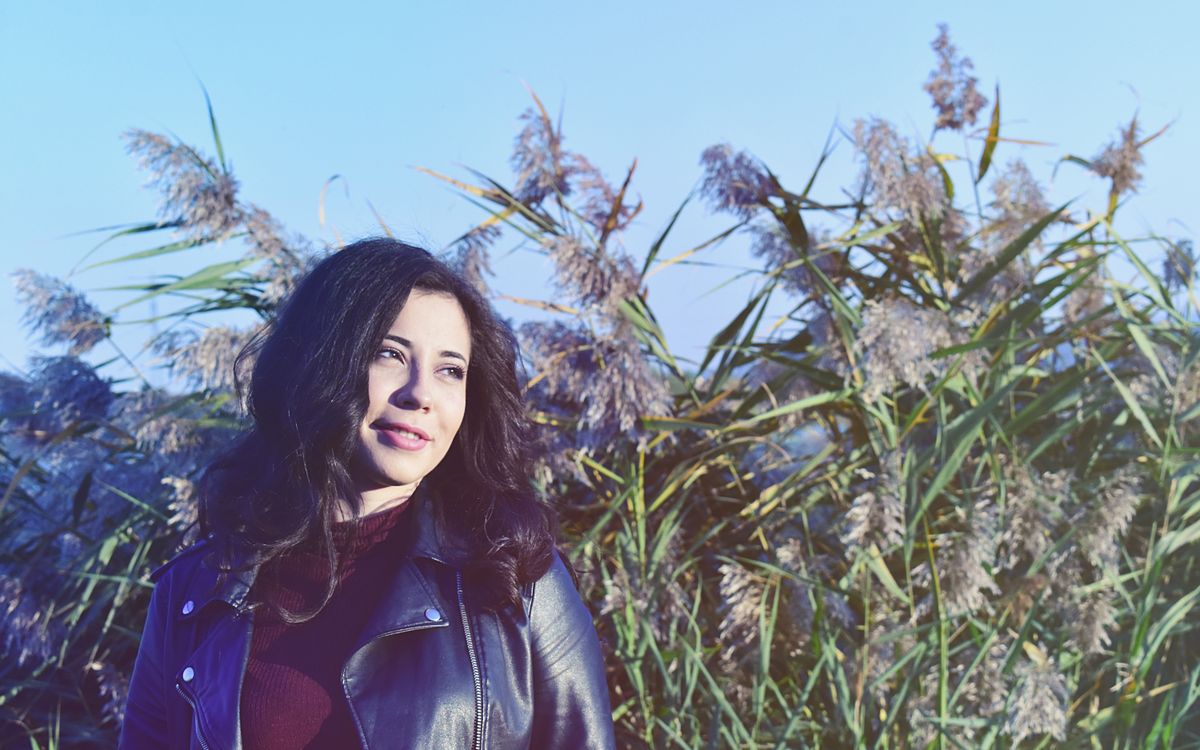 A person wearing a leather jacket, relaxed outdoor lifestyle shot